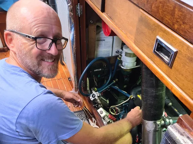 Marine engine maintenance being carried out aboard a cruising sailboat